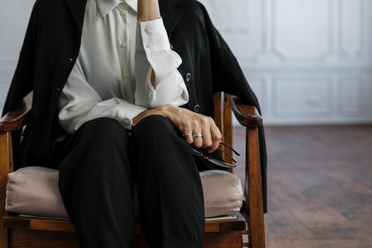 一位职业女性坐在办公室的扶手椅上，神情平静，若有所思