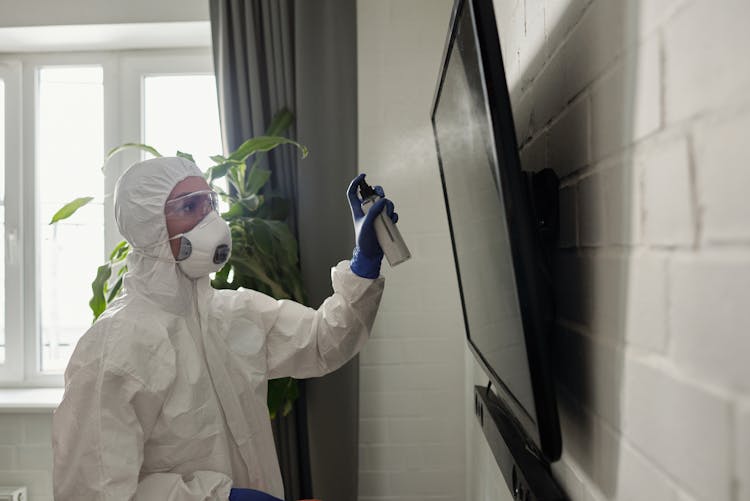 A Person Cleaning The Flat Screen TV