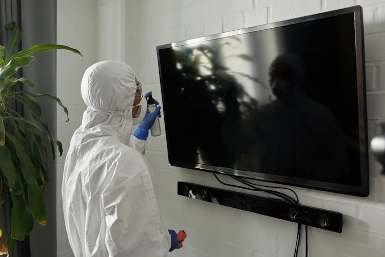 A Person Cleaning The Flat Screen TV