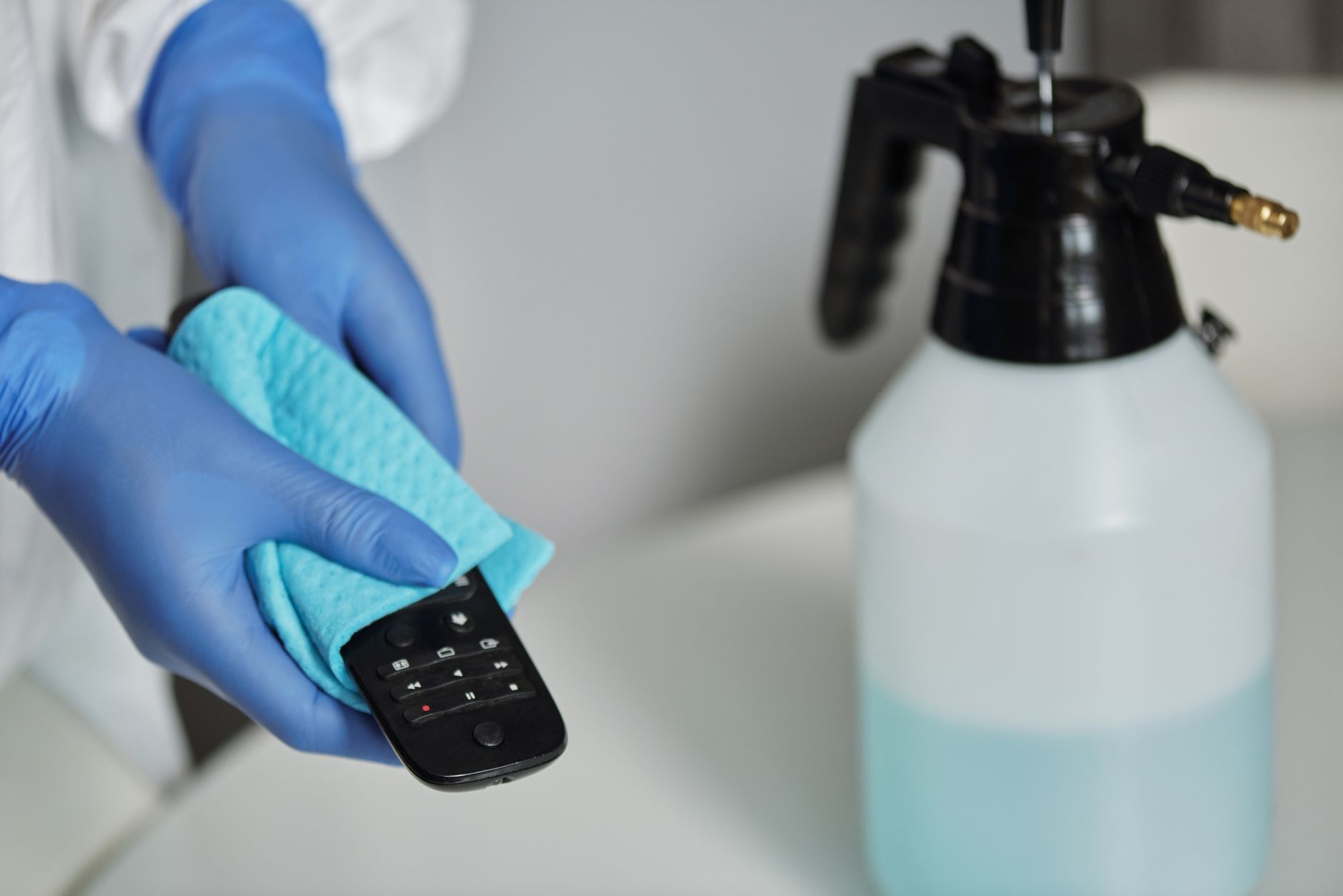 Technicien appliquant un produit désinfectant sur une surface avec attention et précision