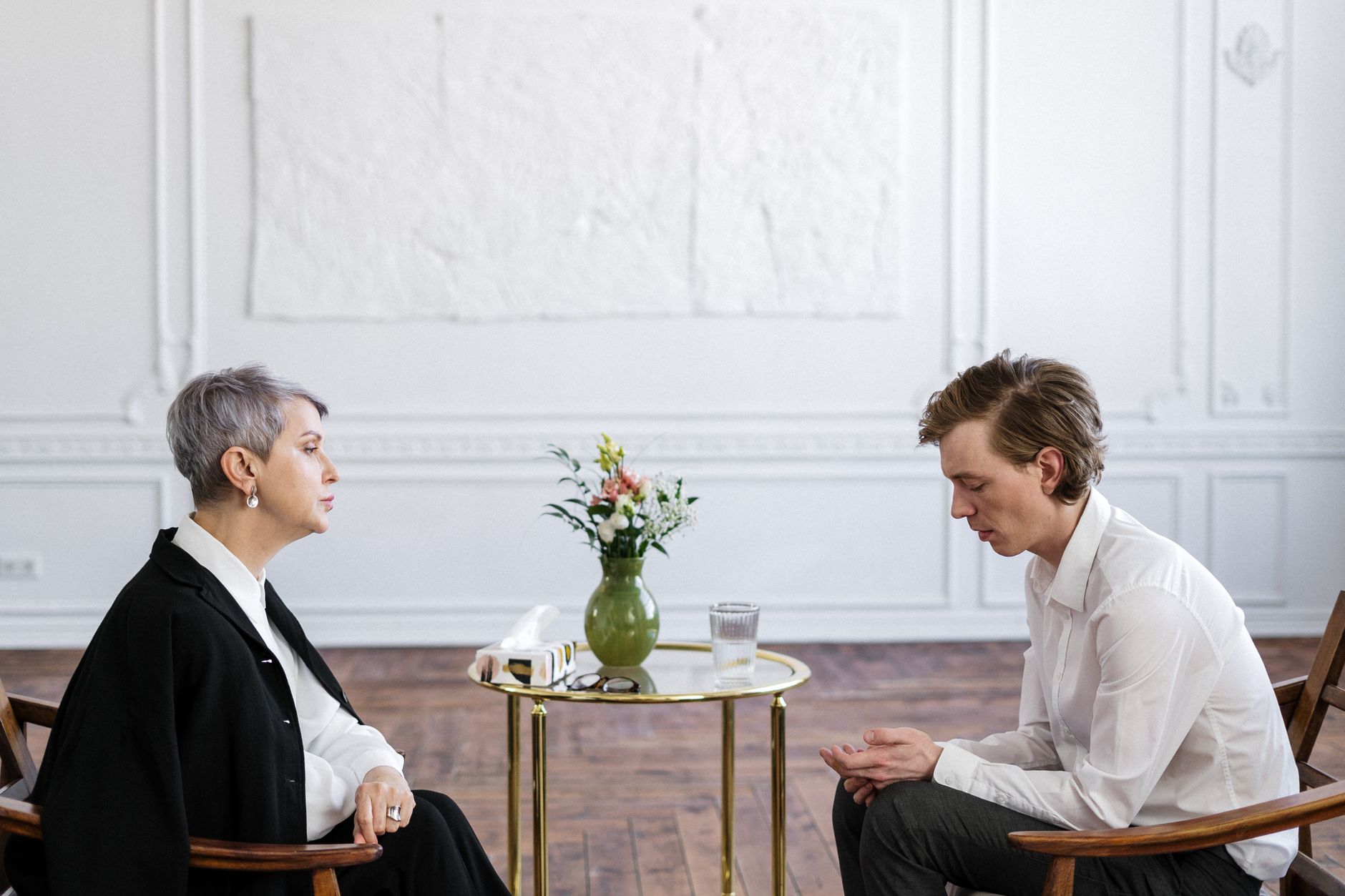 A therapist and patient engage in a private counseling session in a serene office setting.