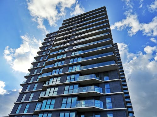 Edificio A Pannelli Di Vetro Blu E Grigio Sotto Il Cielo Nuvoloso