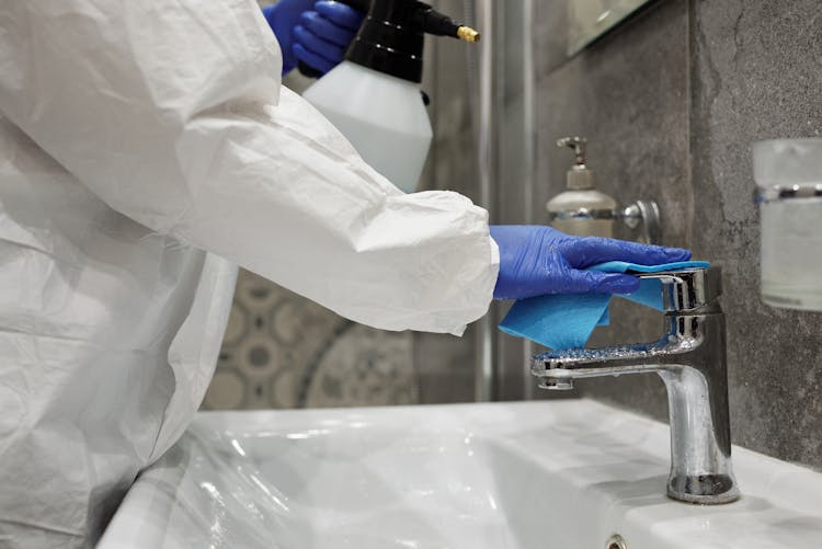 A Person Cleaning The Toilet Sink