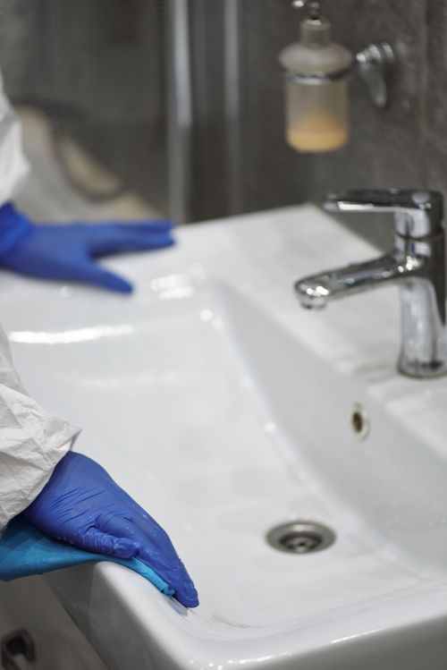 Free Close-up of a washbasin being cleaned with blue gloves, emphasizing sanitation and hygiene. Stock Photo