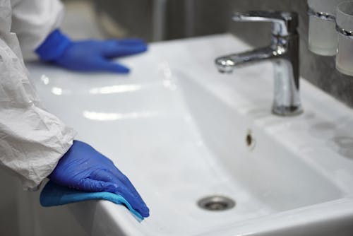 Free Person in Latex Gloves Cleaning Washbasin  Stock Photo