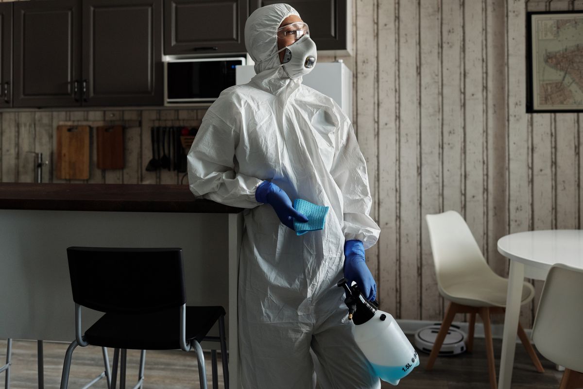 Technicien en combinaison de protection pour un nettoyage de scène de crime