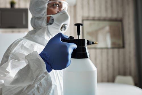 Cleaner with Spray Bottle in Hand During Disinfection