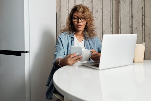 Woman Using Her Phone While Drinking Coffee