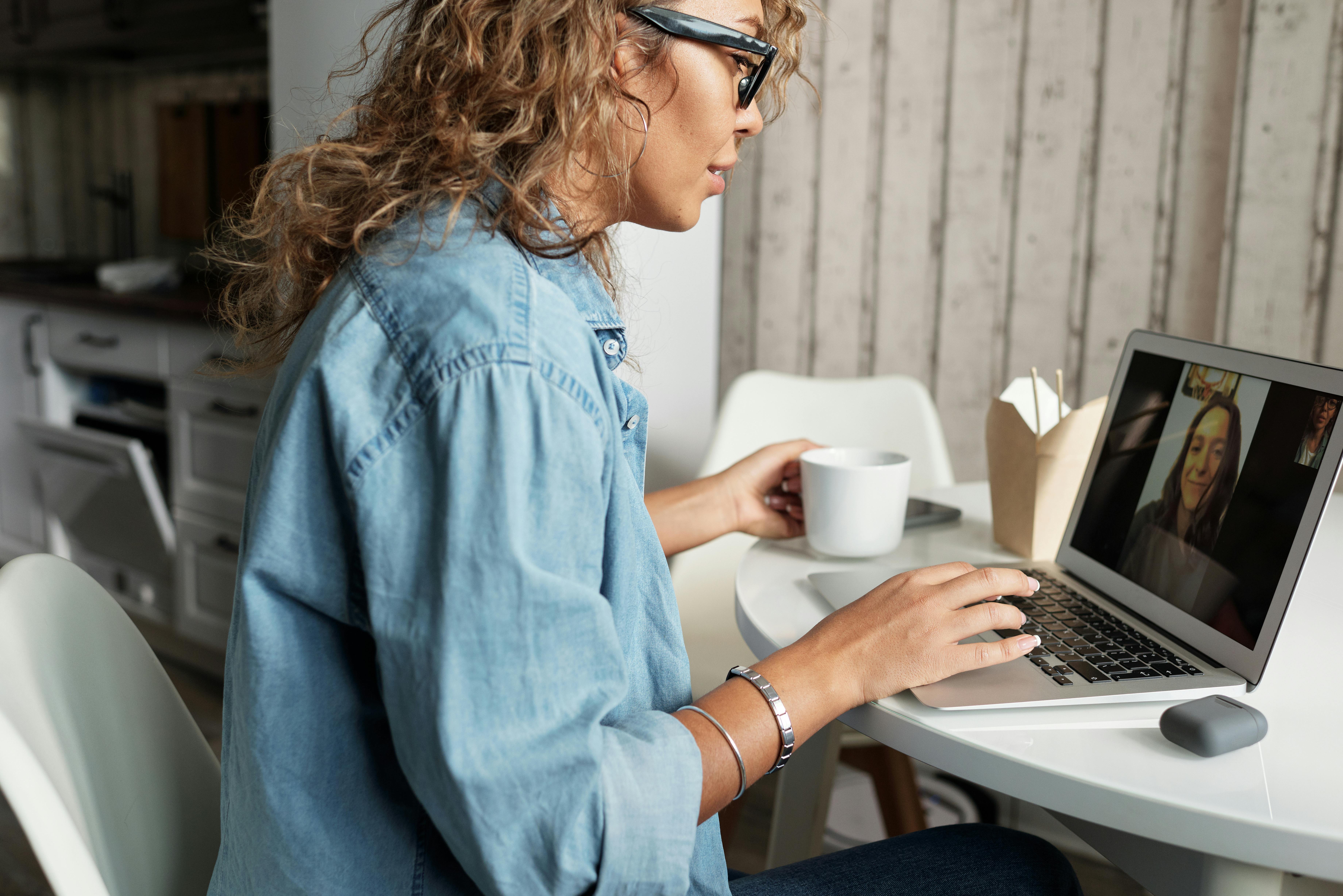 woman in blue denim jacket using macbook pro