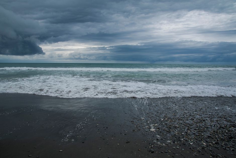 Stunning view of a stormy beach with dramatic clouds in New Zealand.