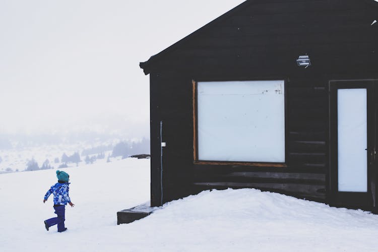 Child Running Neara House In Winter