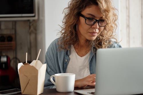 Woman in Denim Shirt Using Laptop