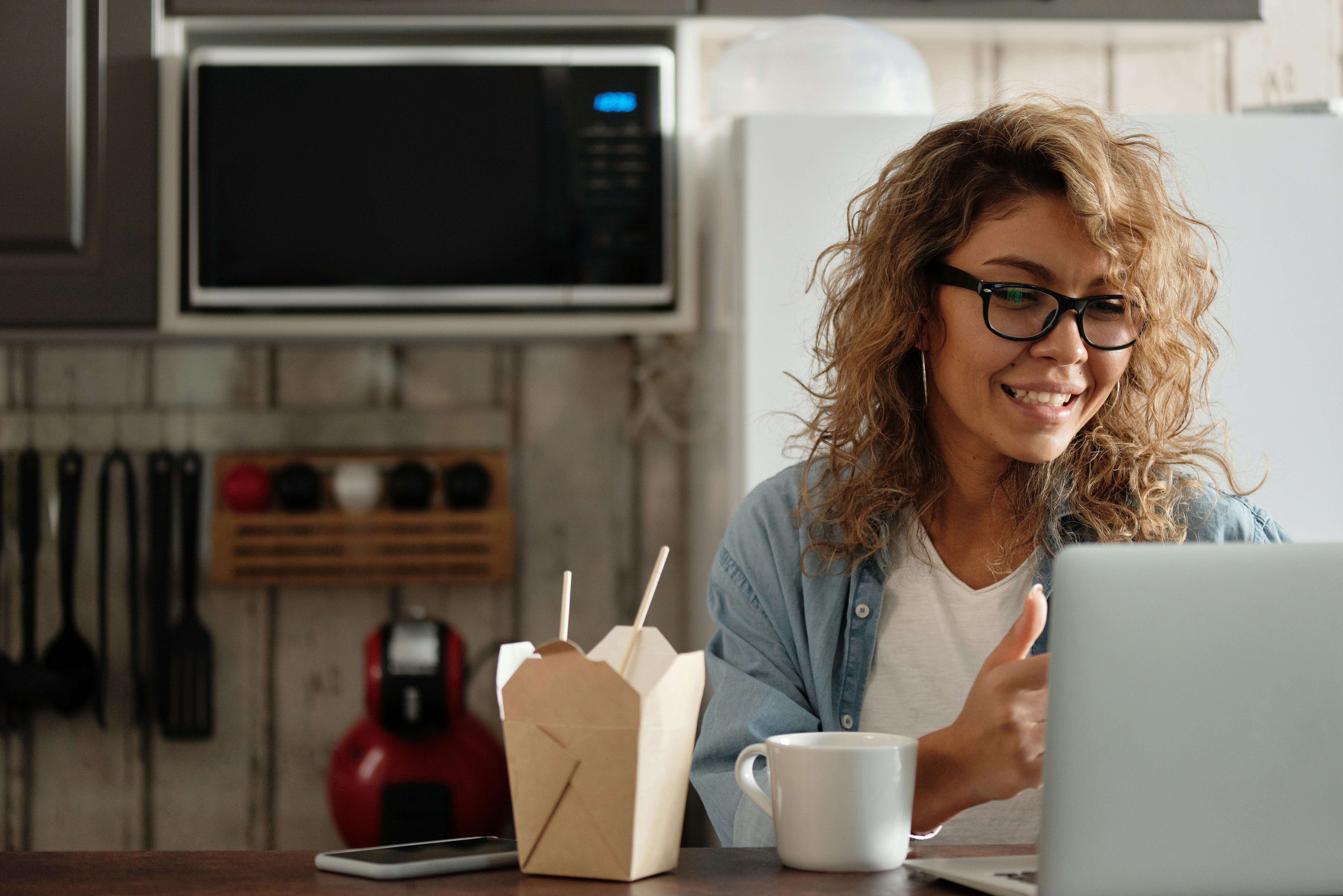 woman in blue denim jacket holding white ceramic mug