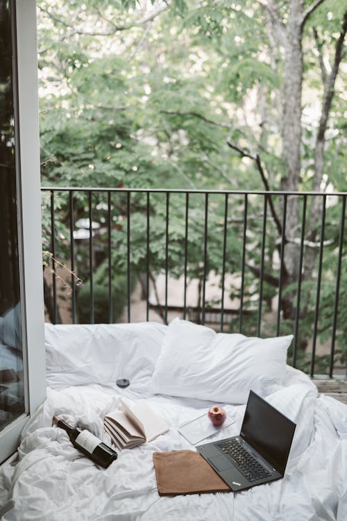 Free Laptop On Bed Near The Balcony Stock Photo