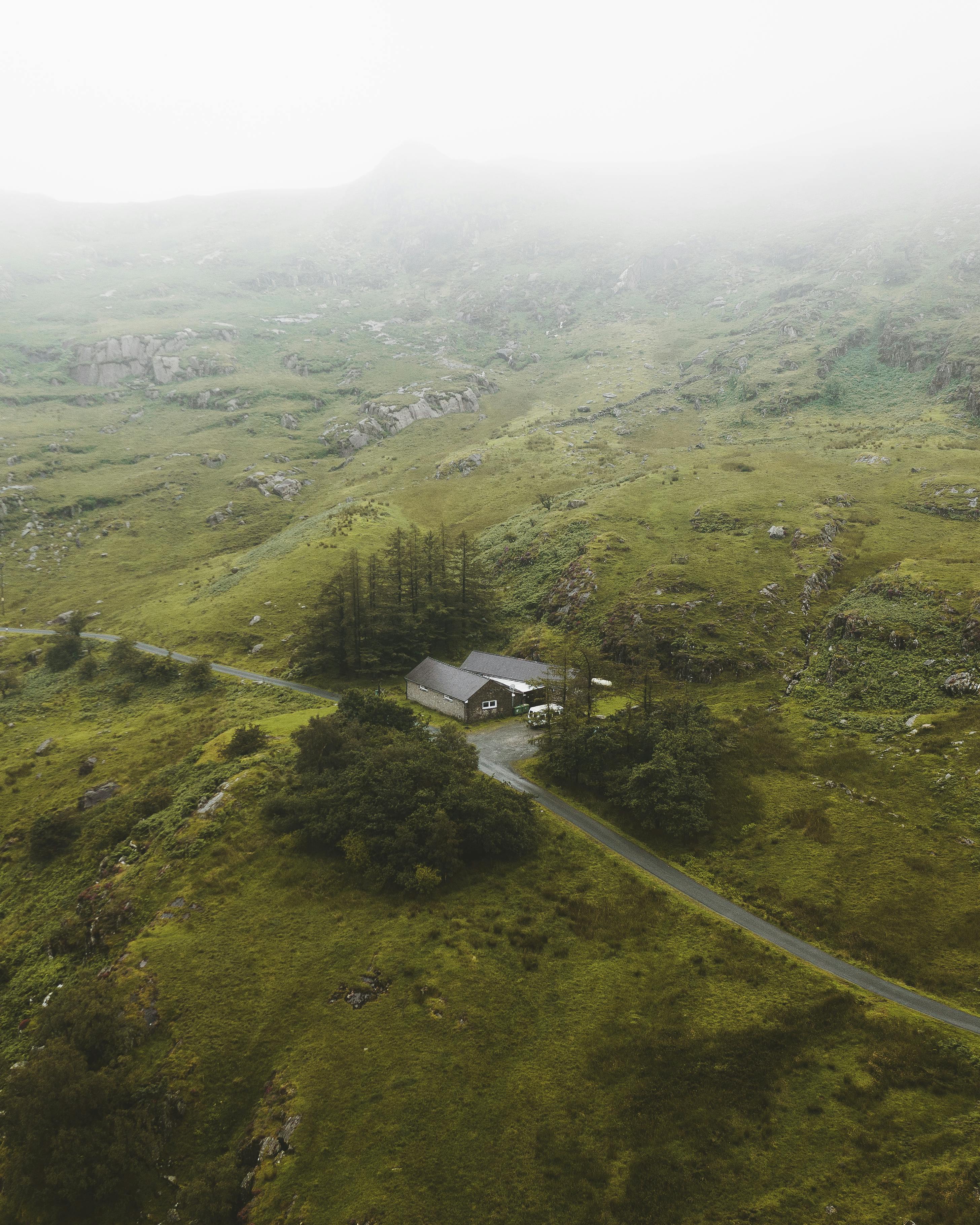 Discover the tranquil beauty of Gwynedd's misty hills and valleys in this serene aerial view.