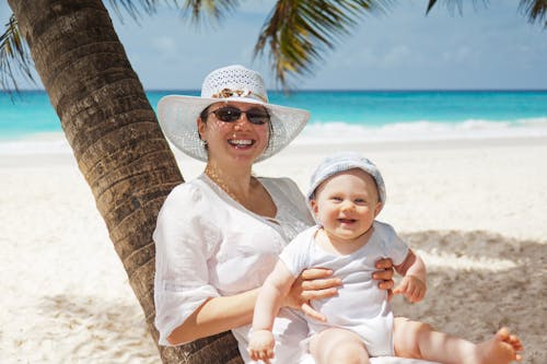 Free Woman Holding Infant on Beach Stock Photo