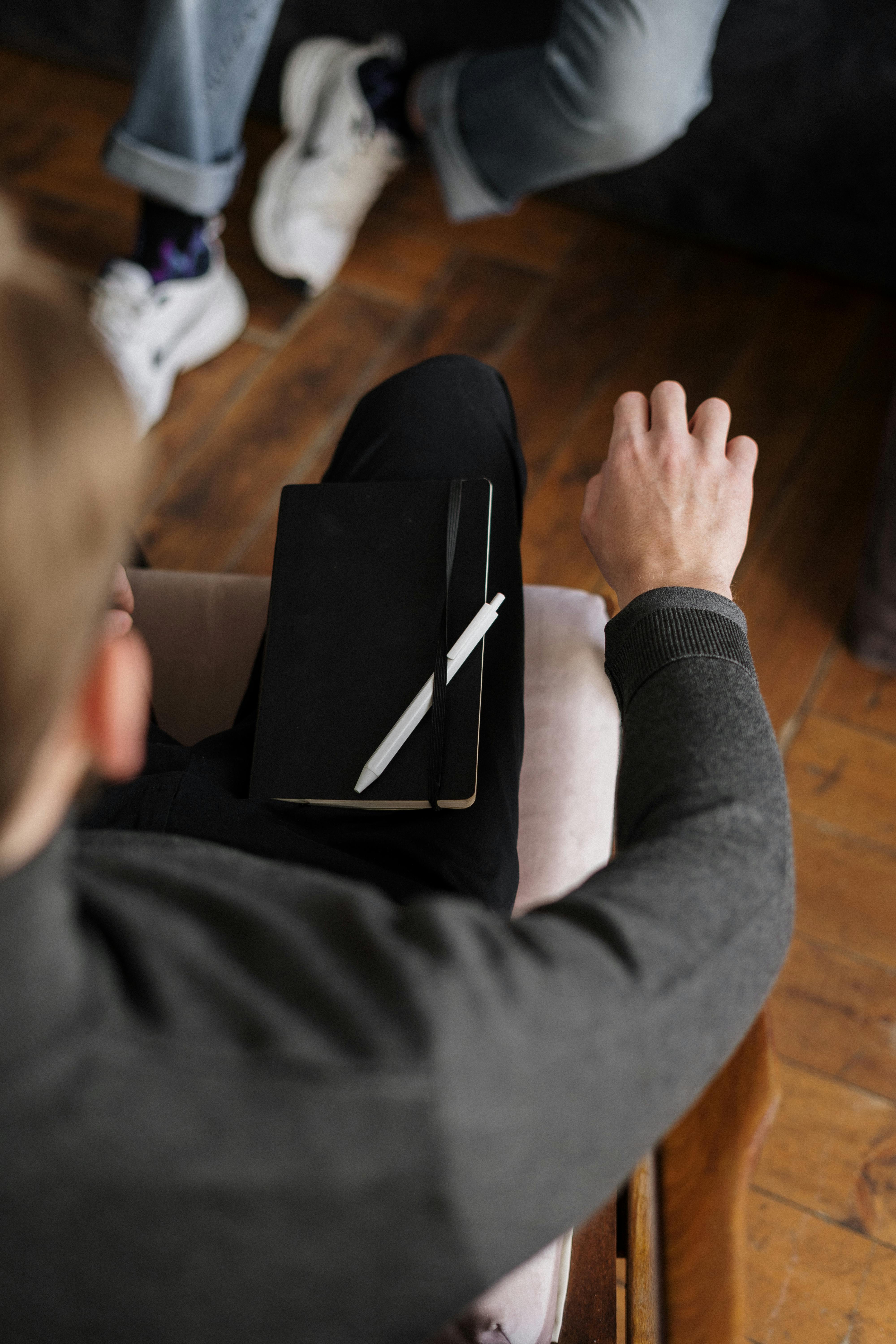 person in gray long sleeve shirt holding black tablet computer
