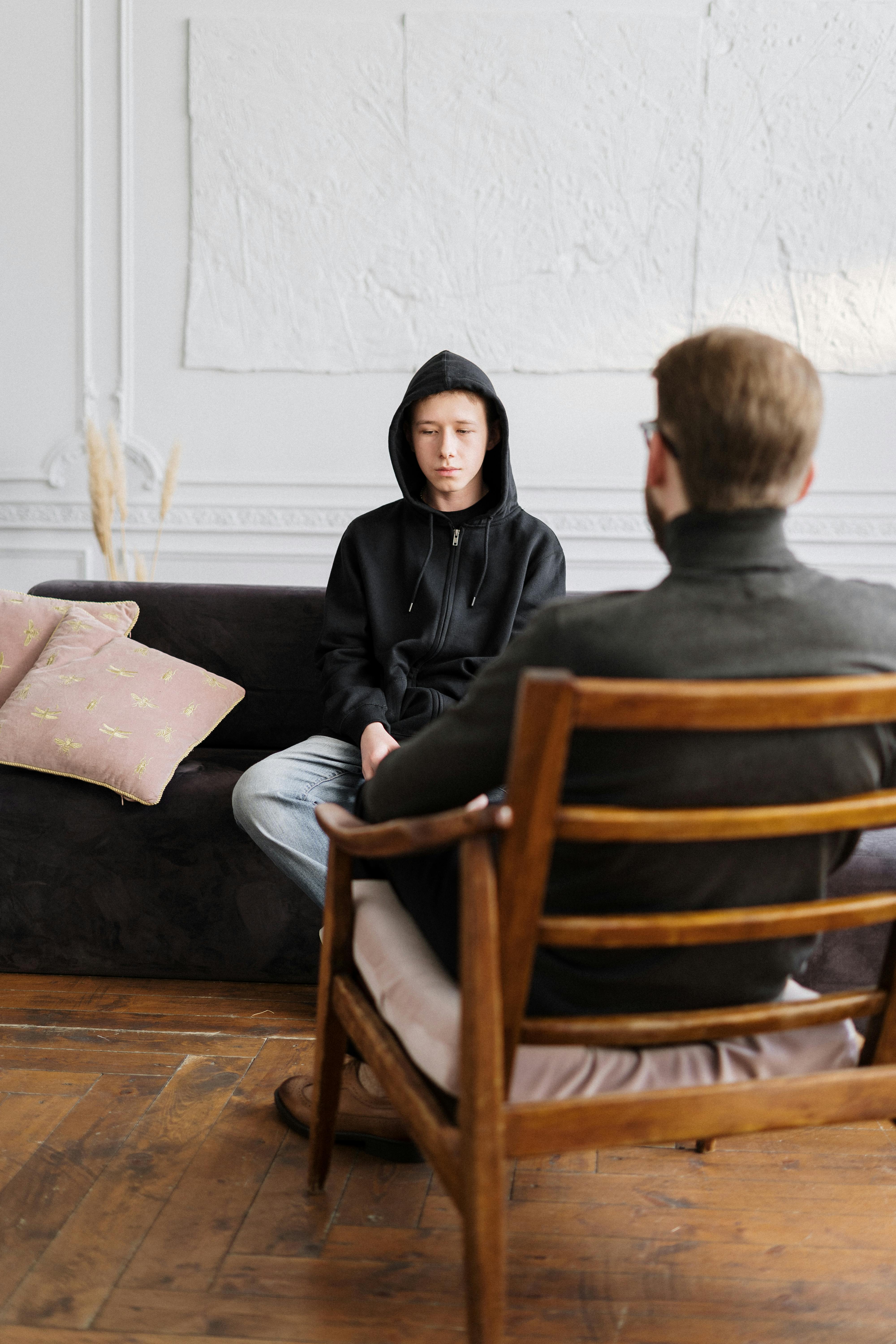 woman in black hijab sitting on brown wooden chair