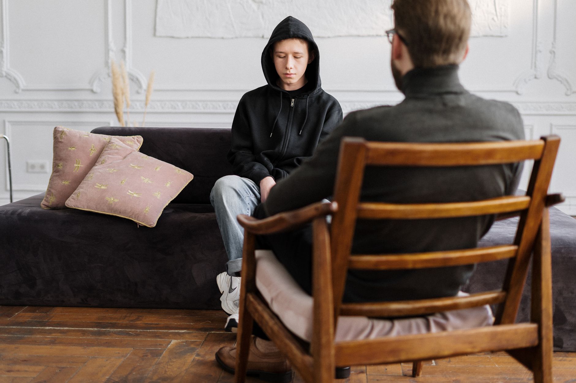 A teenager sits with a counsellor, a reminder that access only matters if someone answers on the other end.