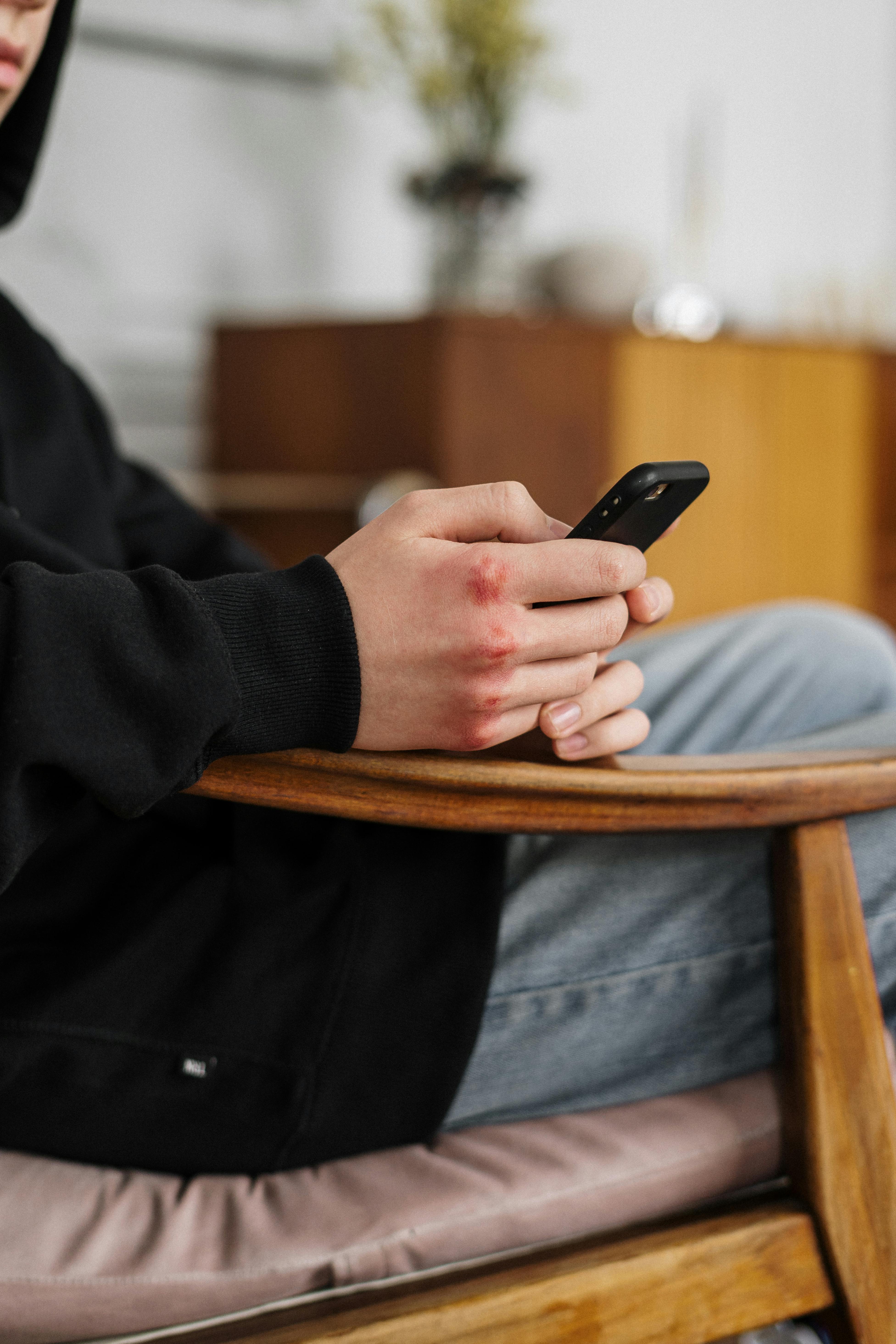 man in black jacket holding black smartphone