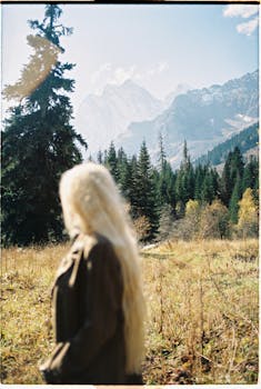 金发女子欣赏着森林和山脉的风景，一派宁静