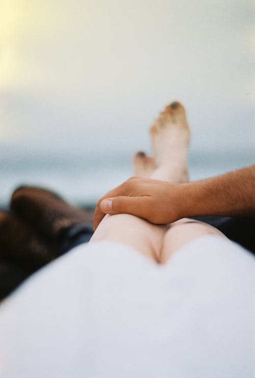 Free Man's Hand on a Woman's leg Stock Photo