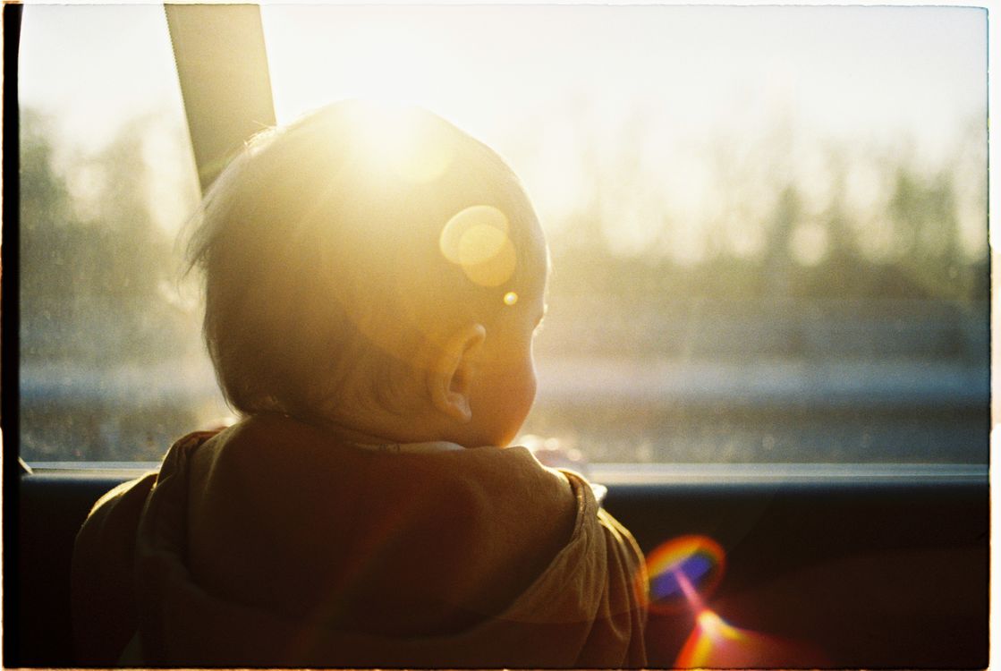 Bébé en voyage en voiture – sécurité et confort Bébé regardant par la fenêtre d'une voiture pendant un voyage en famille