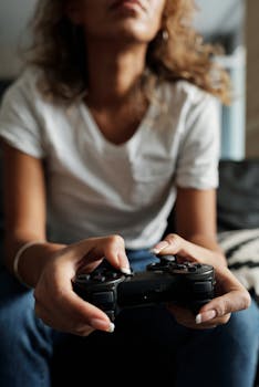 A woman in casual wear plays video games indoors using a wireless controller, focusing on leisure and entertainment.