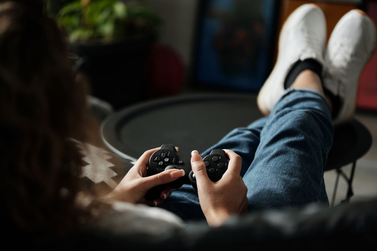 close up of woman gaming with a controller feet propped up enjoying le
