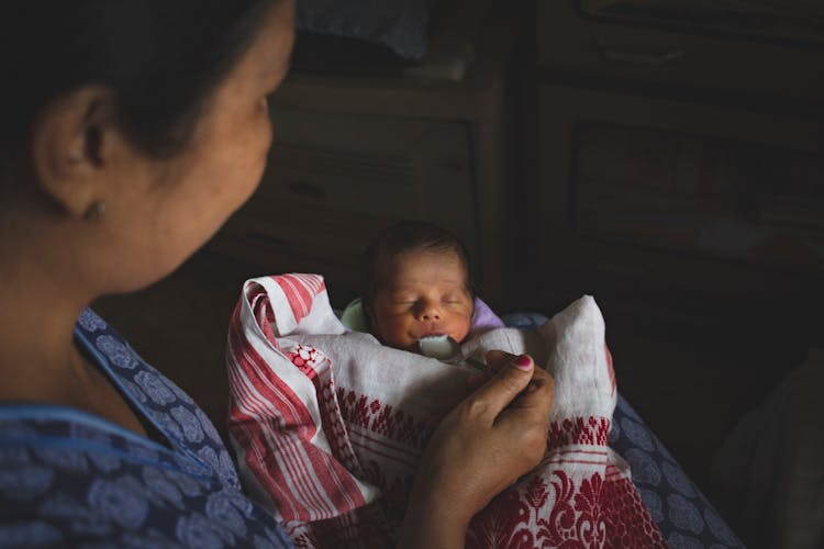 A Mother Milk Feeding The Newborn Baby Using A Spoon