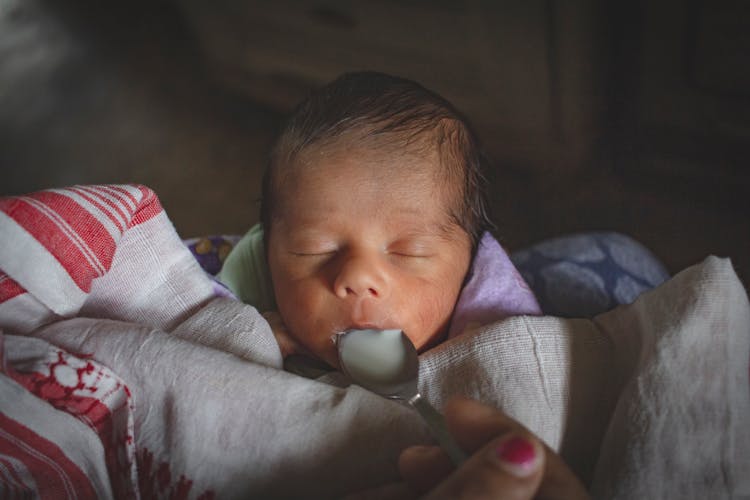 A Newborn Baby Milk Feeding Using A Spoon