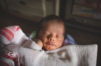 可爱的新生婴儿被毯子和平包裹着，睡在室内