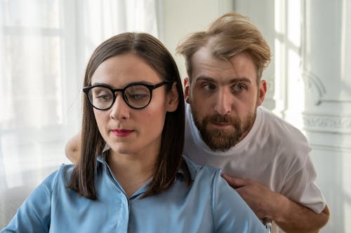 Man in Blue Polo Shirt Beside Woman in White Crew Neck T-shirt