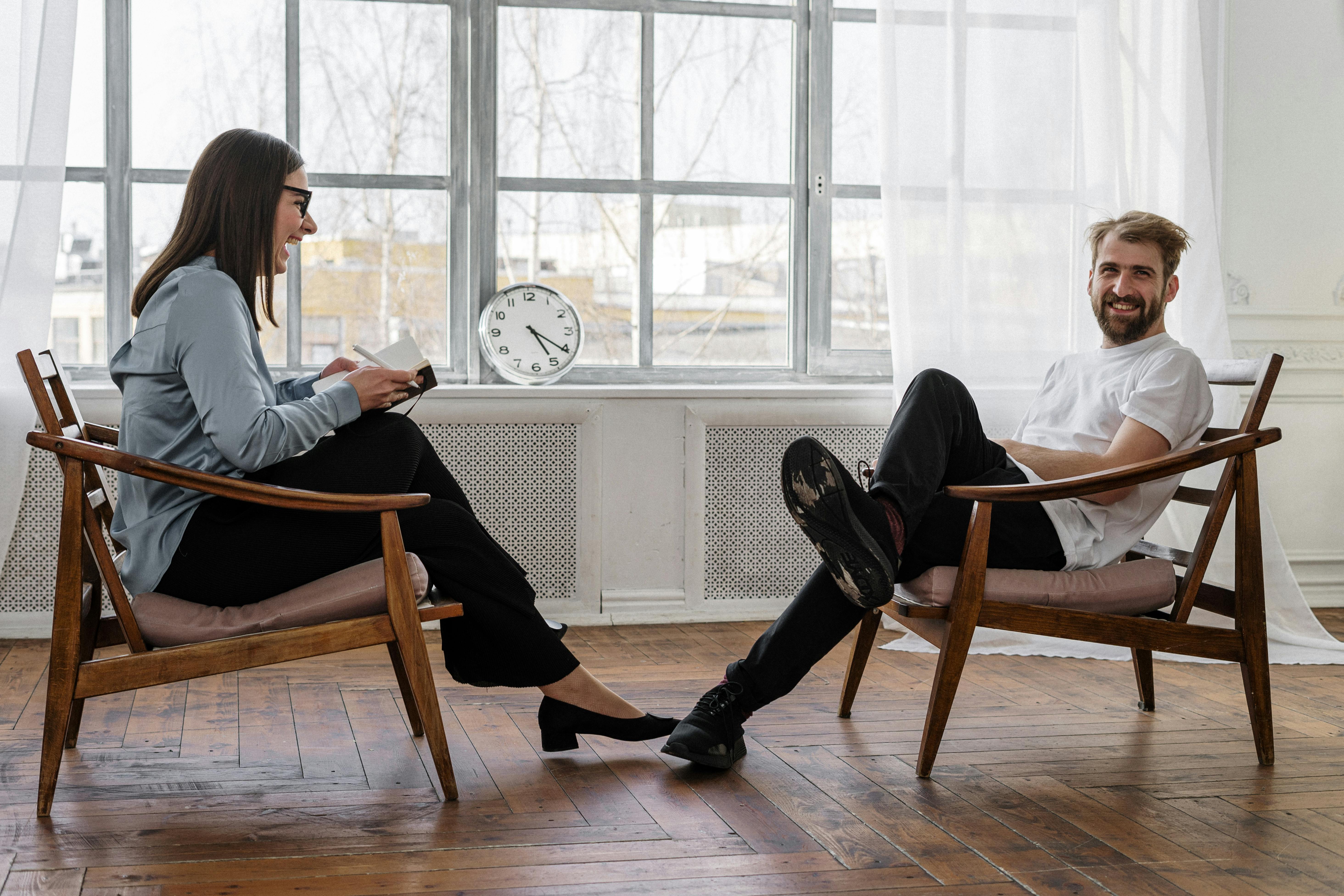 2 women sitting on brown wooden chair