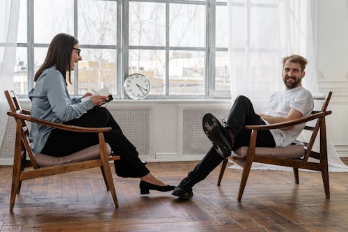 Free 2 Women Sitting on Brown Wooden Chair Stock Photo