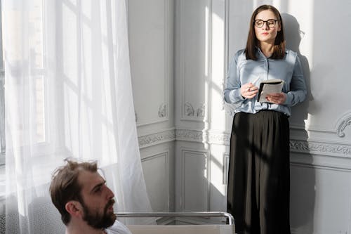 Man and Woman Standing Beside Window