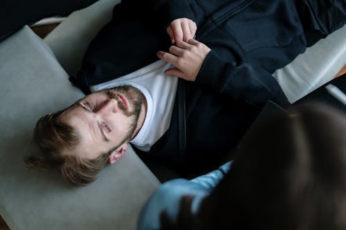 Man in Black Jacket Lying on White Pillow