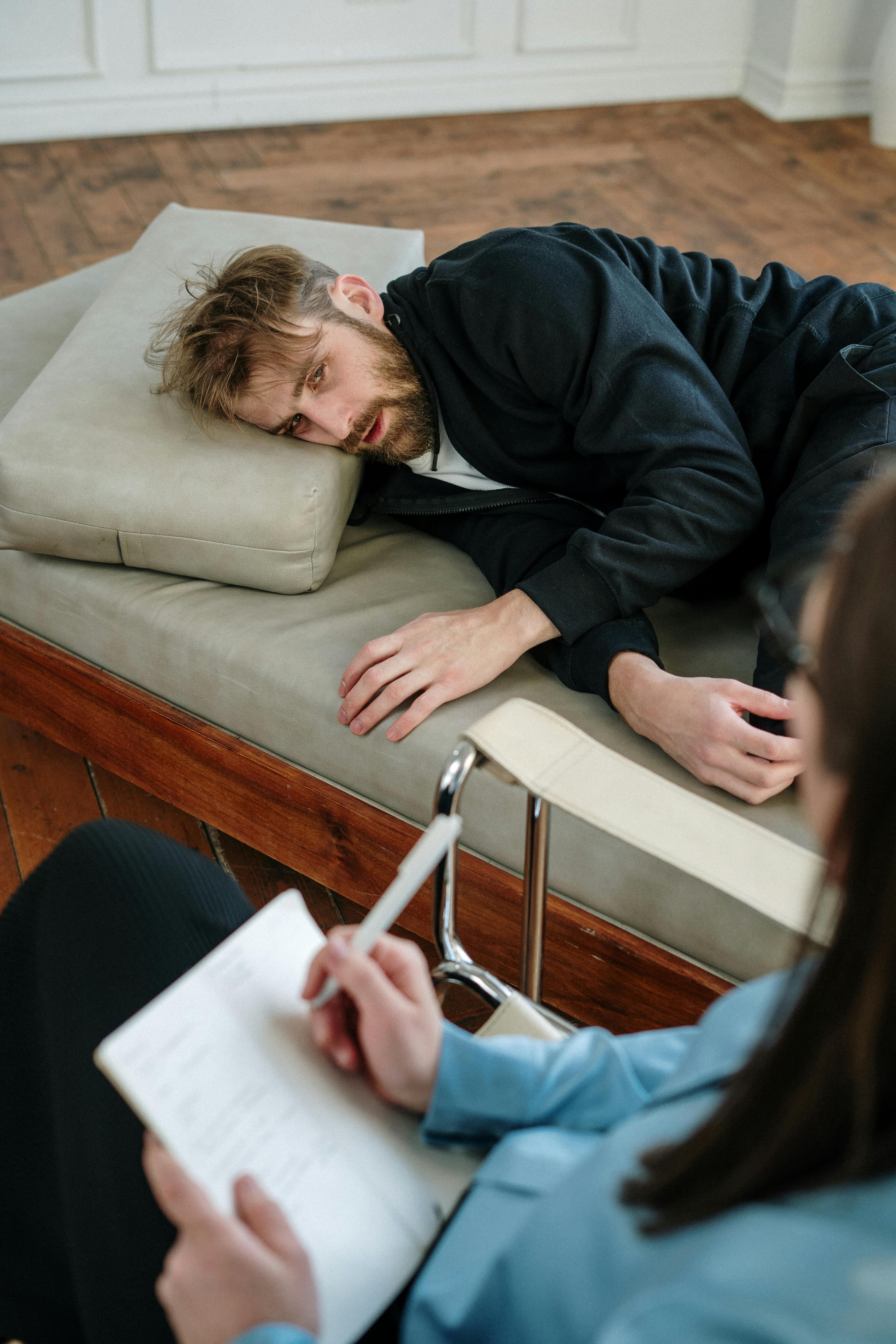 man in black jacket lying on couch