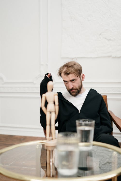 Man in Black Suit Sitting on Brown Wooden Chair