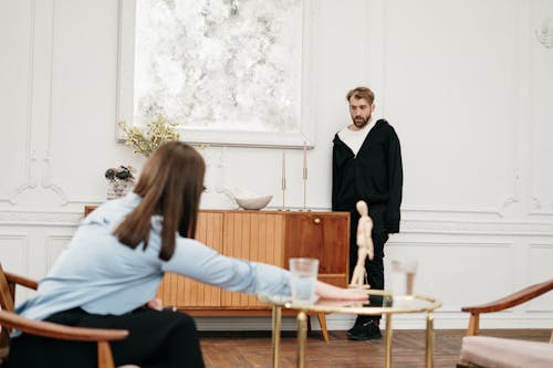 Man in Black Suit Jacket Sitting Beside Woman in White Long Sleeve Shirt