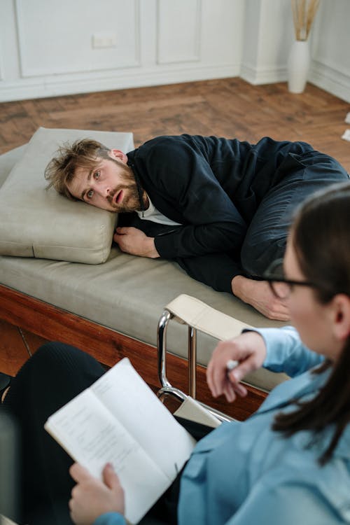 Free Man in Black Jacket Lying on Couch Stock Photo