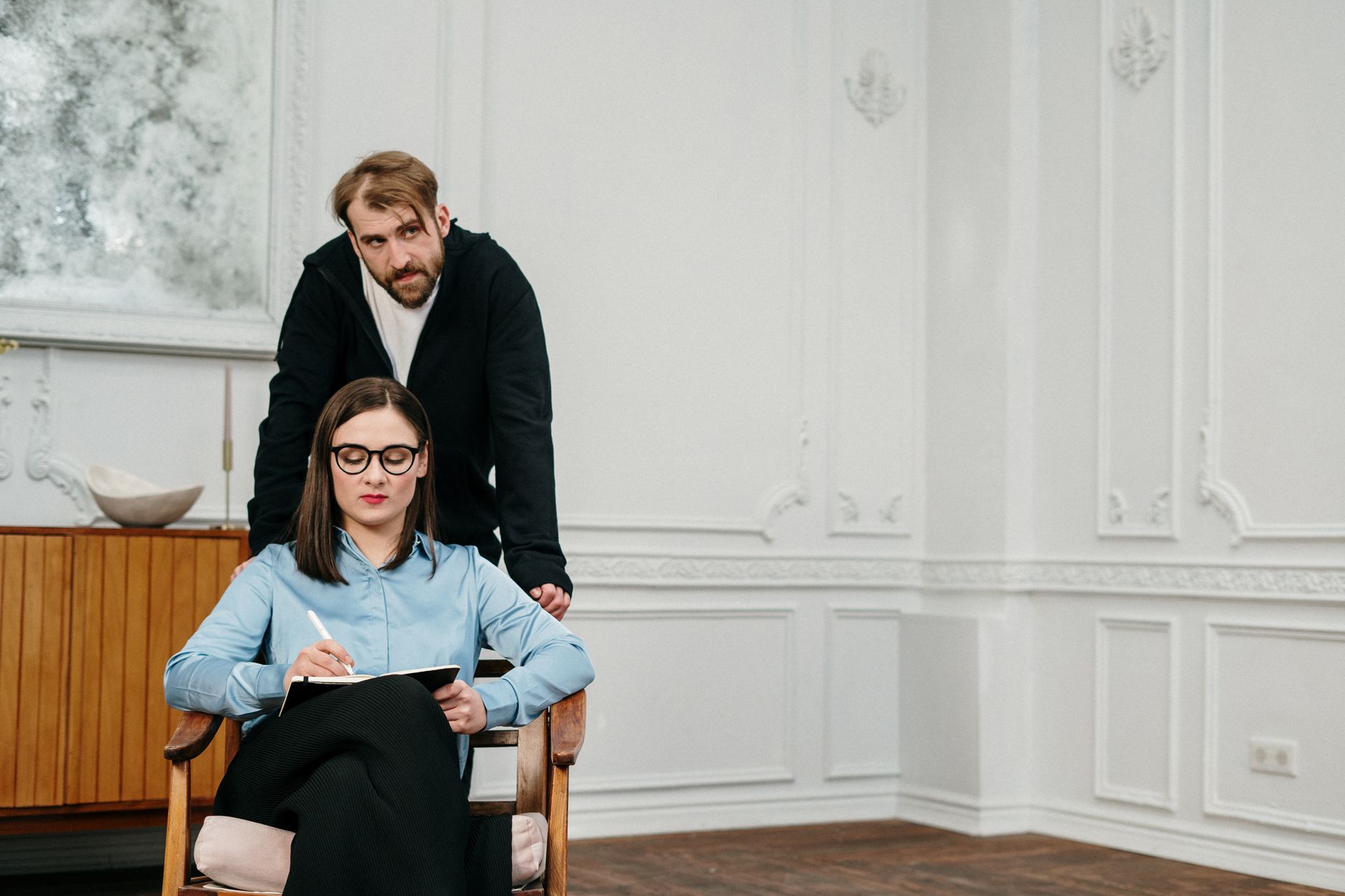 A bearded man consulting with a female professional in a stylish office space.