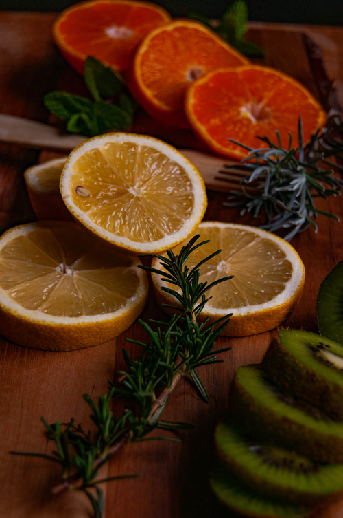 Free Colorful composition of citrus and kiwi slices with herbs on wooden background. Stock Photo
