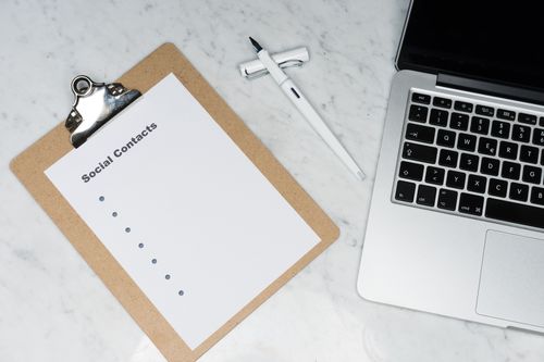 Free Minimalist workspace featuring a clipboard, laptop, and pen on a marble surface. Stock Photo