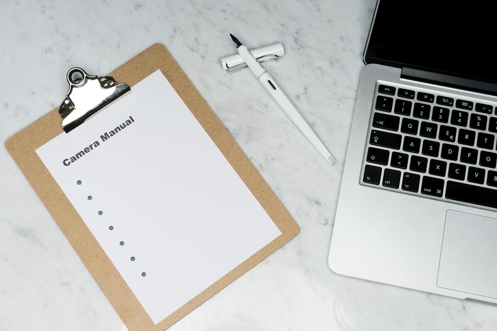 Checklist stampata con una penna vicino a un laptop su marmo