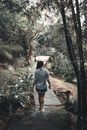 Woman in Blue Denim Jacket Walking on Wooden Bridge