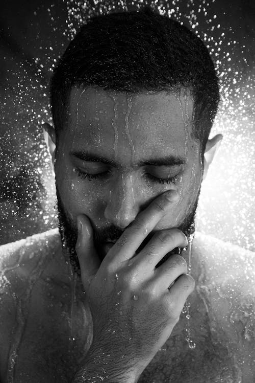Grayscale Photo of a Man Taking Shower