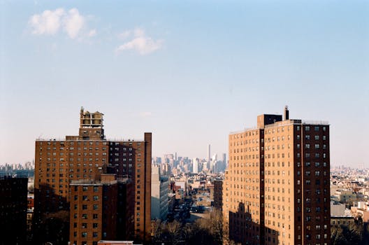 A scenic view of New York apartment buildings with a city skyline in the background. by Brandon Nickerson