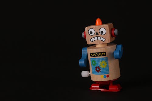 Free Close-Up Shot of a Wooden Robot Toy on a Black Surface Stock Photo