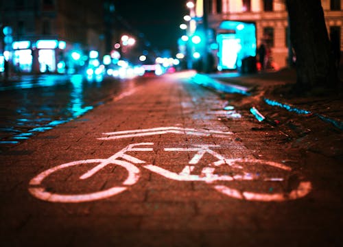 Selective focus of marking for cyclist and blue neon lights of city at night